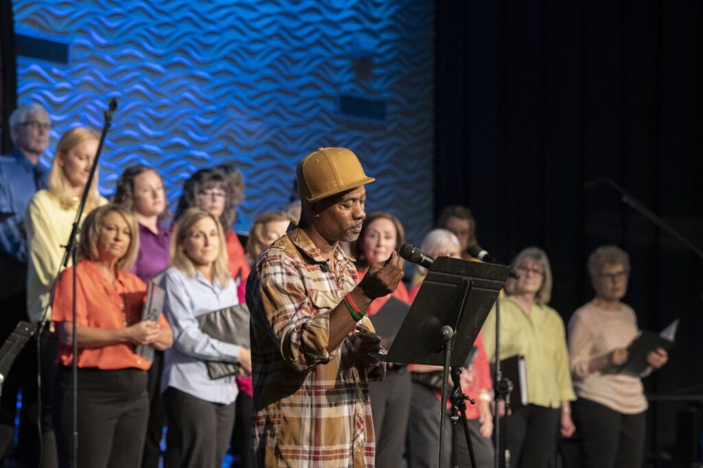 Charlotte spoken word artist Jah Smalls performing with the North Mecklenburg Community Chorus. Photo by Jon Strayhorn.